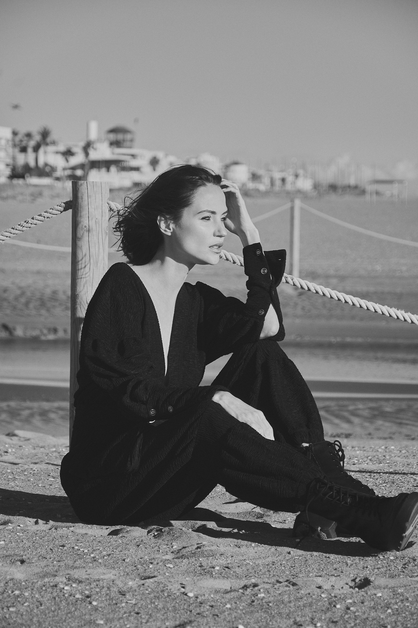 Fashion model sitting on Castelldefels beach for coastal fashion editorial