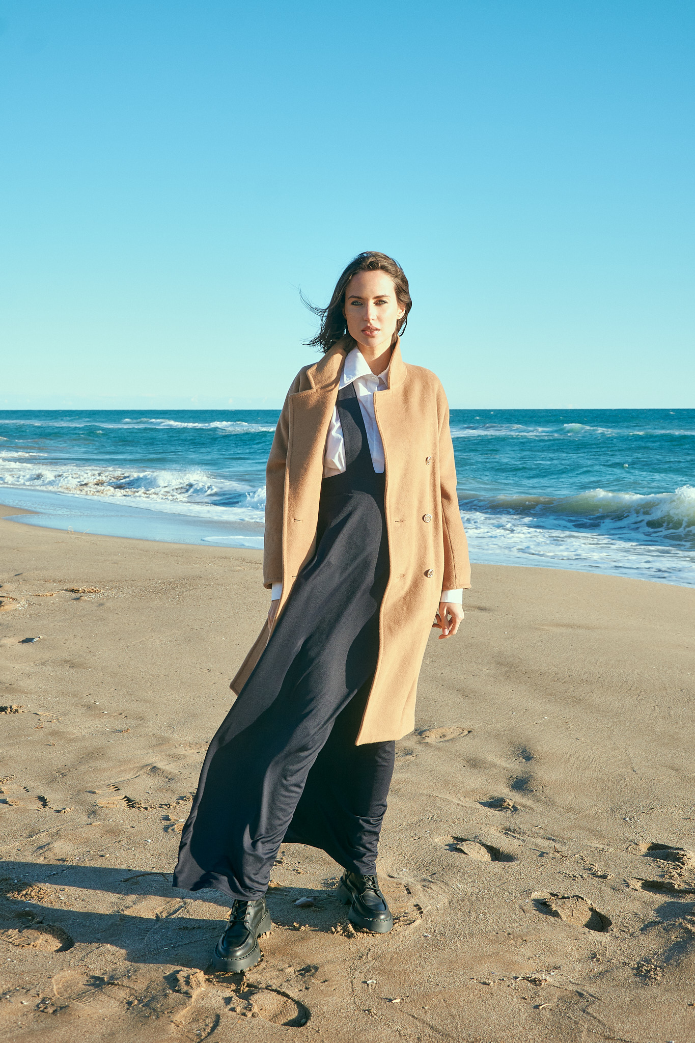 Fashion model walking on Castelldefels beach for coastal fashion editorial near Barcelona