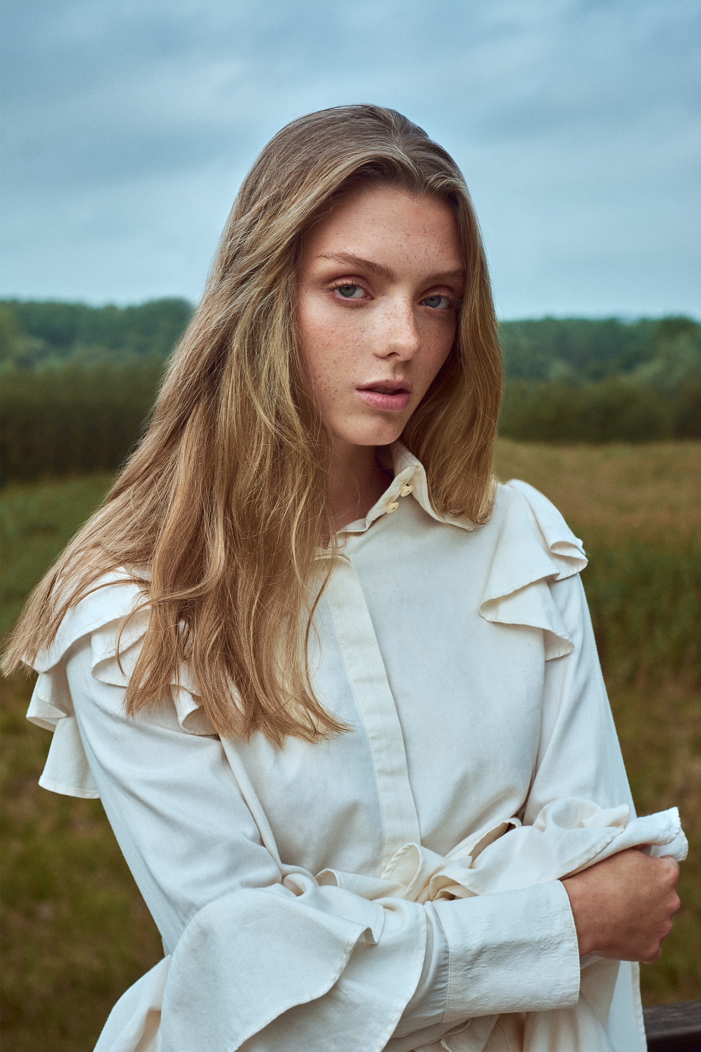 fashion editorial portrait model in white blouse countryside
