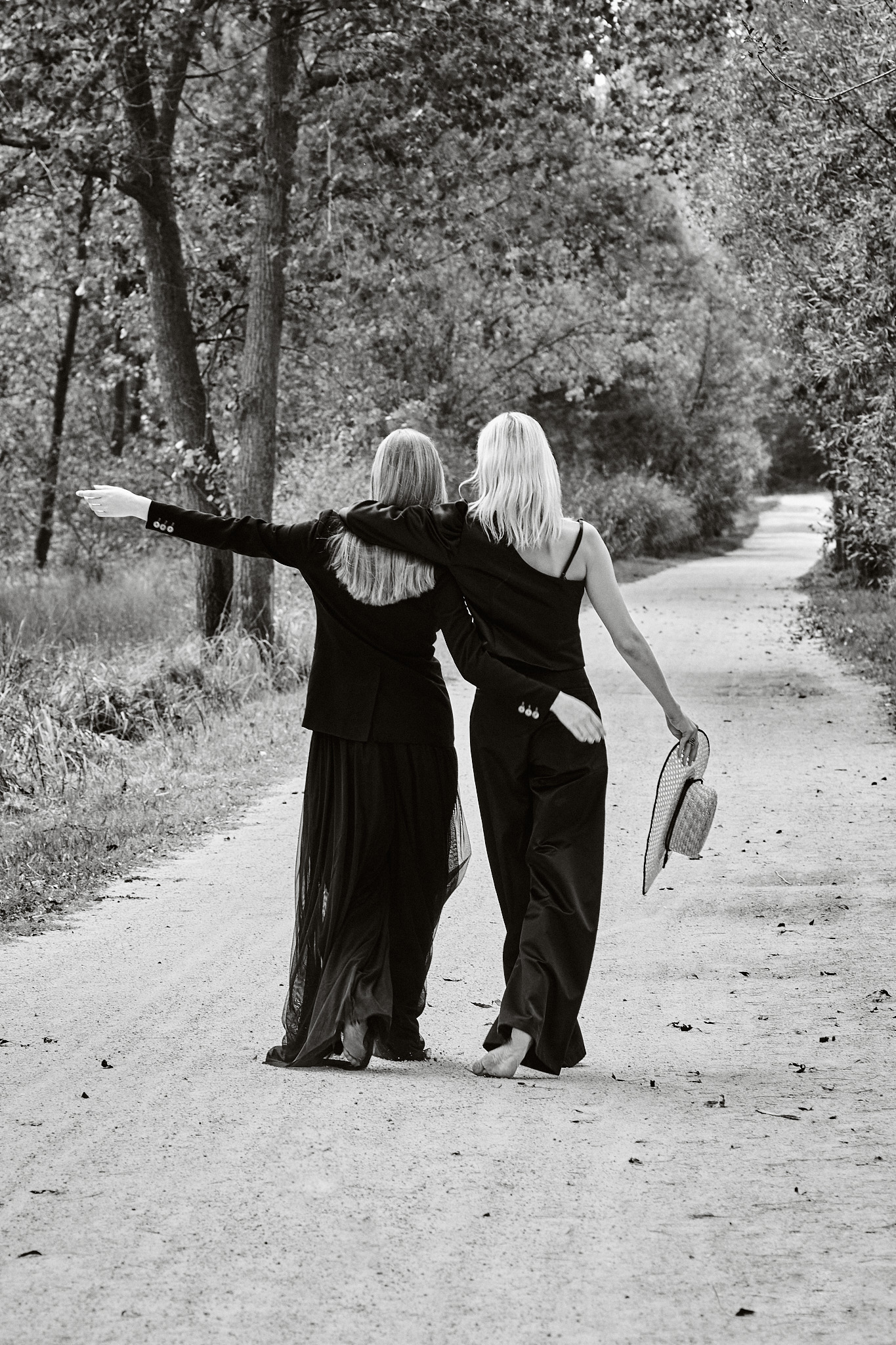 black and white fashion editorial models walking countryside path
