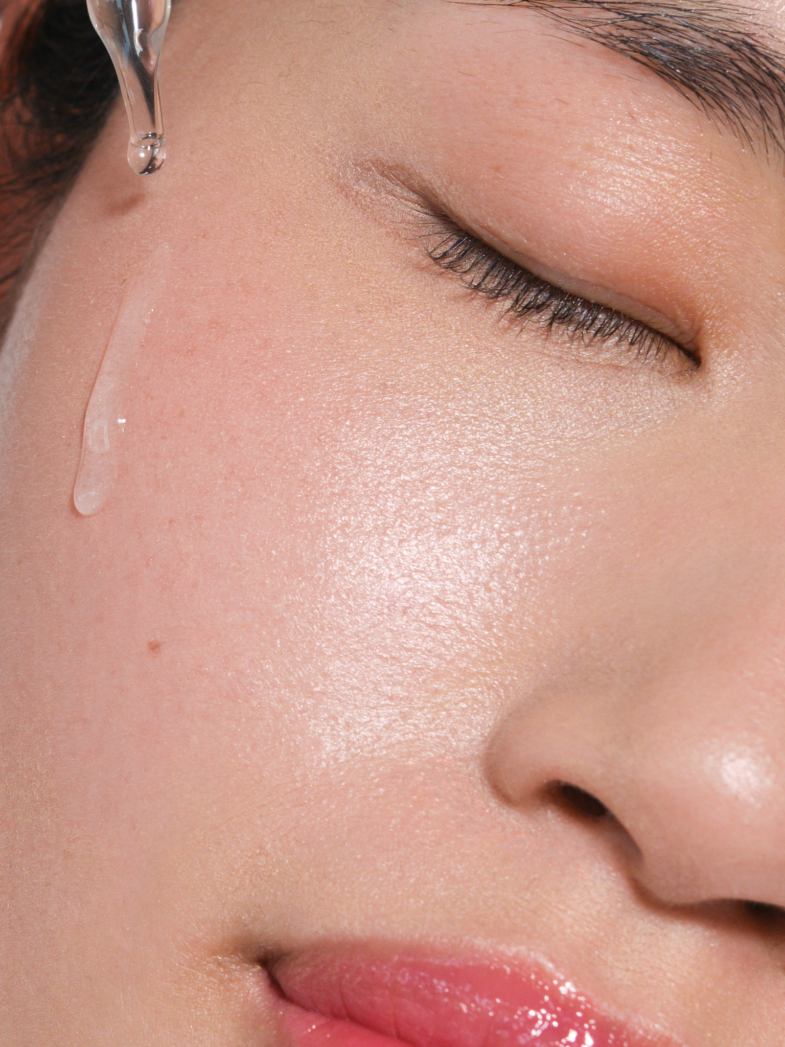 Close-up beauty portrait applying Byoode serum — skincare campaign for Moodka